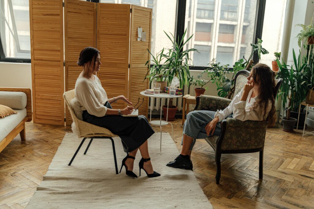 pexels-photo-5217851-5217851 Two women sit in a therapy session, creating a tranquil and professional environment.
